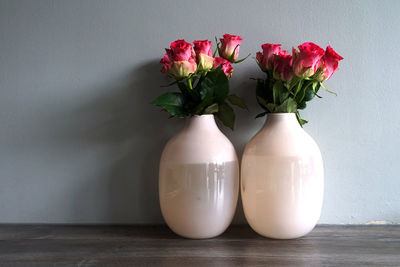 Close-up of white flower vase on table against wall