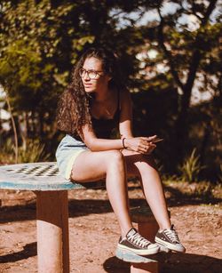 Young woman sitting on tree