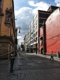 People walking on street amidst buildings in city