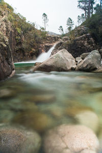 Scenic view of waterfall against sky