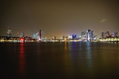 Illuminated erasmus bridge and cityscape at night