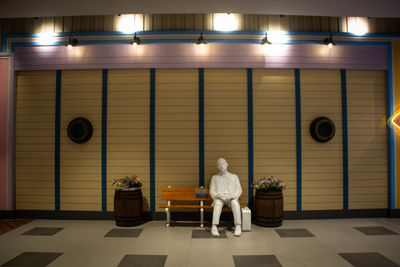 Rear view of woman sitting on seat in illuminated room