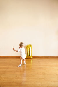 Full length of woman standing on wooden floor at home