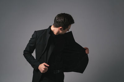 Young man standing against white background