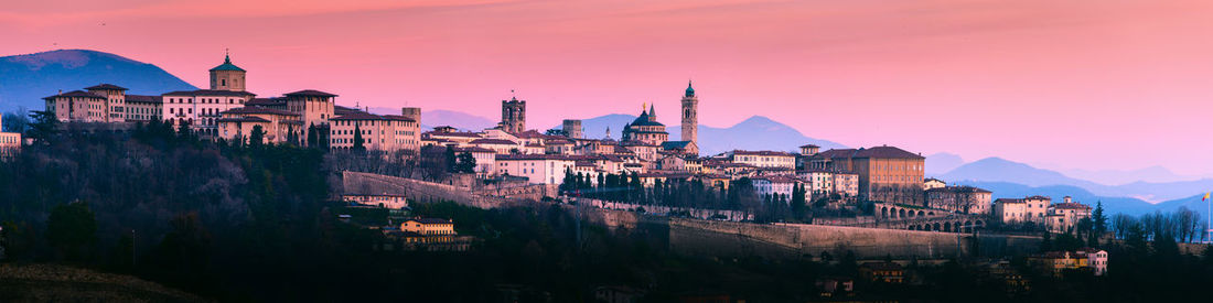 Panoramic view of buildings in city against sky during sunset