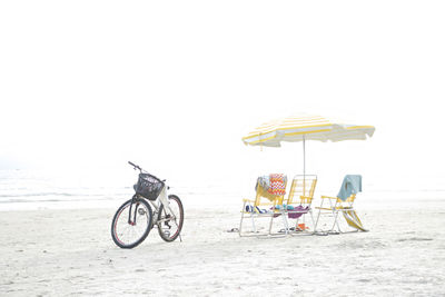 Bicycle on beach against clear sky