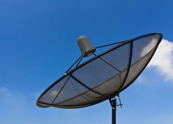 Low angle view of telephone pole against blue sky