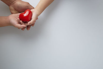 Midsection of woman holding hands against white background