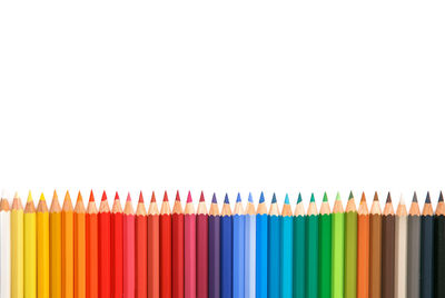 Close-up of colored pencils over white background