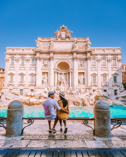 Rear view of couple in front of historical building