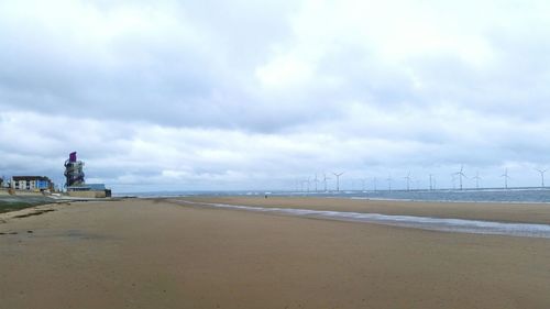 View of beach against cloudy sky