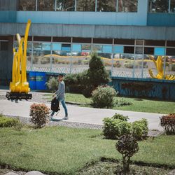 Full length rear view of man walking by built structure