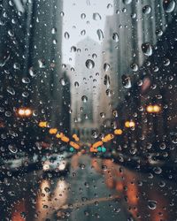 Car on street seen through wet car window during monsoon