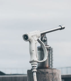 Close-up of watergun against sky