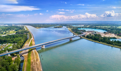 Bridge over river in city against sky