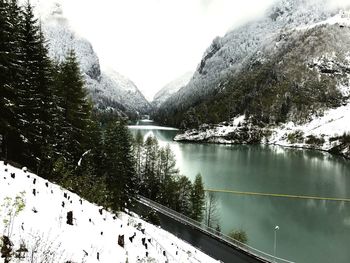 Scenic view of lake by snow mountains against sky