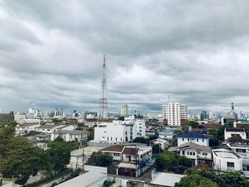 Buildings in city against cloudy sky