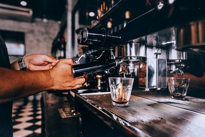 Midsection of man using coffee machine