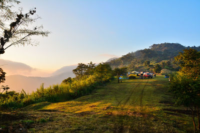 Vehicle on landscape at sunset