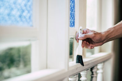 Close-up of woman hand holding window