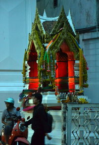 Statue of people in temple against sky