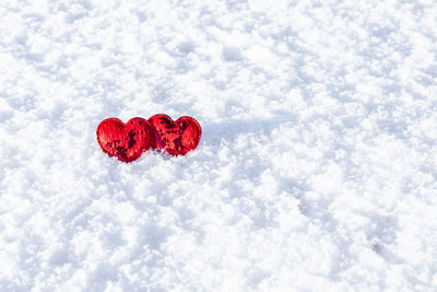 Two red hearts on a background of white snow. place for an inscription. copyspace. valentine's day.