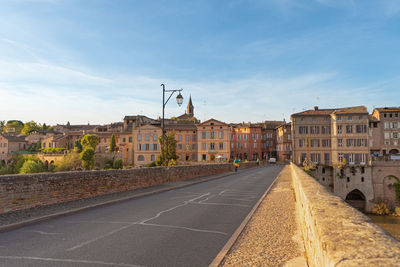 Surface level of road by buildings against sky