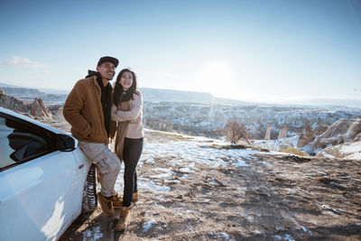 Side view of couple standing on snow