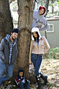 Portrait of happy friends standing by tree trunk