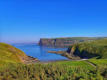 Scenic view of sea against clear blue sky