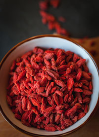 Close-up of dried goji berries in bowl on dark background