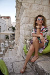 Portrait of smiling young woman sitting outdoors