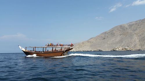 Boats in sea with mountain in background