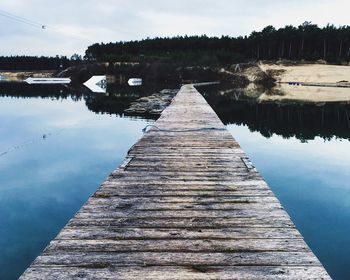 Pier amidst lake against trees