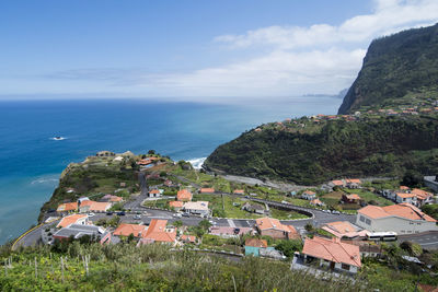 High angle view of townscape by sea against sky