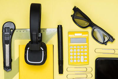 High angle view of objects on yellow background