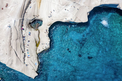 Aerial view of people on land by sea