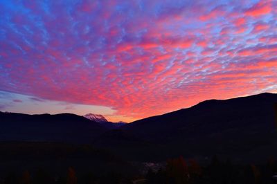 Scenic view of silhouette mountains against orange sky