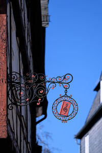 Low angle view of decoration hanging on building against sky