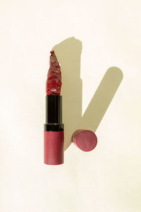Lipstick with hot chilli pepper on top, isolated against a light background. beauty and make-up