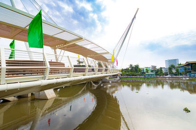 Sailboats moored in river against sky