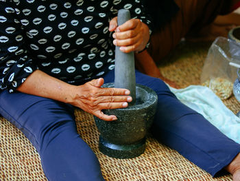 Midsection of woman holding mortar and pestle
