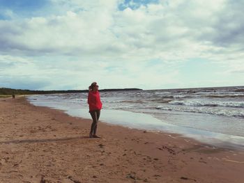 Full length of man walking on beach against sky