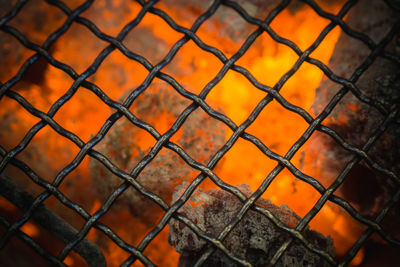 Full frame shot of chainlink fence against fire