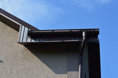 Low angle view of pipes against blue sky