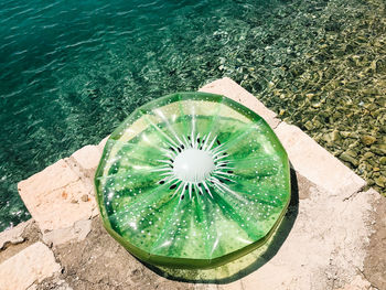 High angle view of green inflatable raft by sea during sunny day