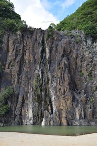 Rock formations by sea against sky