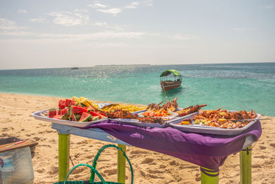 Food on the table - lobsters, potatoes, watermelons and more, on a sandy beach, zanzibar