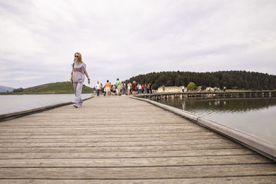 People walking on shore against sky