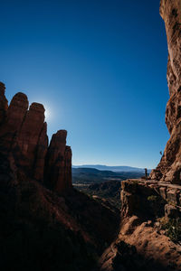 Rock formations on landscape against blue sky